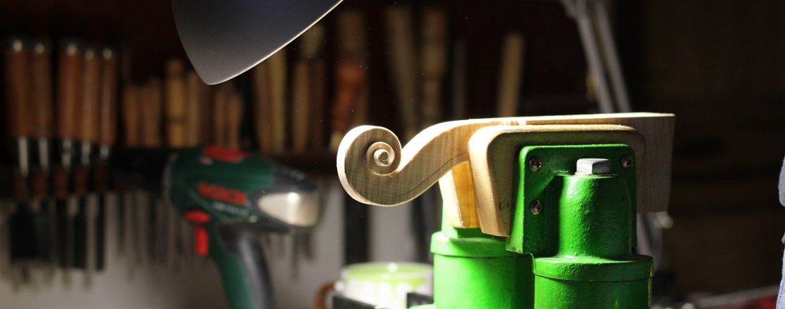 La sculpture d'une volute de violon à l'atelier.