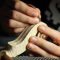 Les mains du luthier en train de façonner la volute du violon